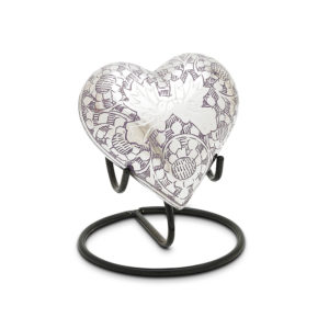 Decorative heart sculpture with pattern on stand.