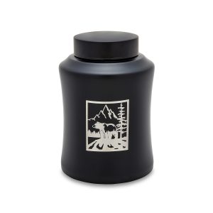 Black candle with mountain and wolf design.